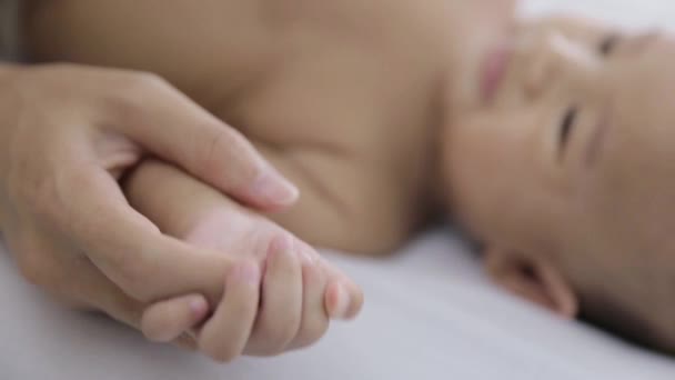 母親と赤ん坊が手を取り合って - 映像、動画