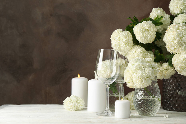 Composition with hydrangea flowers and candles against brown background. Romantic evening - Photo, image