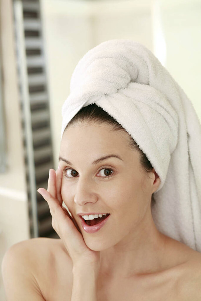 Woman with towel wrapped hair showing shock expression - Photo, image