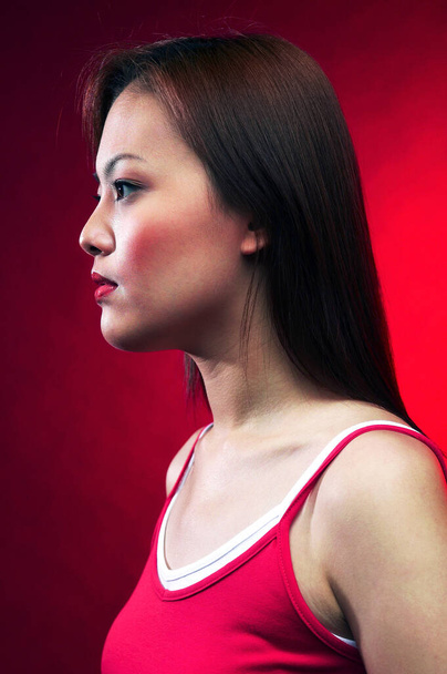 Woman in red top posing on a red background - Photo, image
