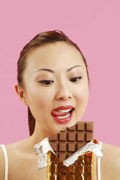 Woman enjoying a chocolate bar - Foto, imagen