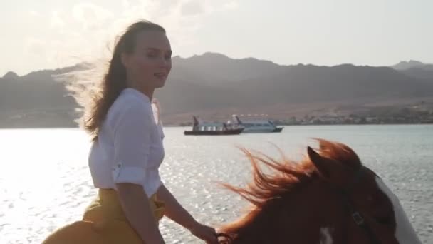 Muotokuva blondi tyttö ratsastus hevonen läpi veden auringonlaskun hidastettuna
 - Materiaali, video