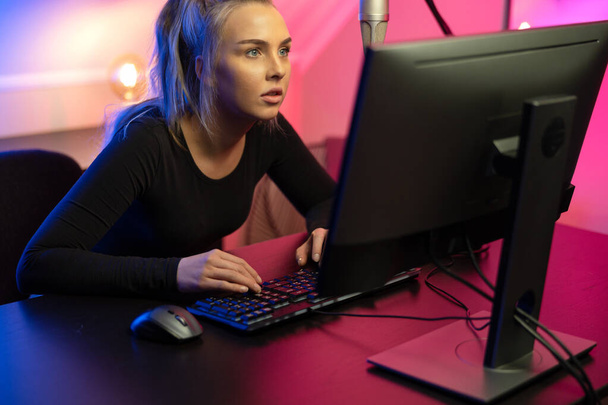 Орієнтована професійна дівчина електронного спорту з гарнітурою Граючи онлайн відеоігри на ПК
 - Фото, зображення
