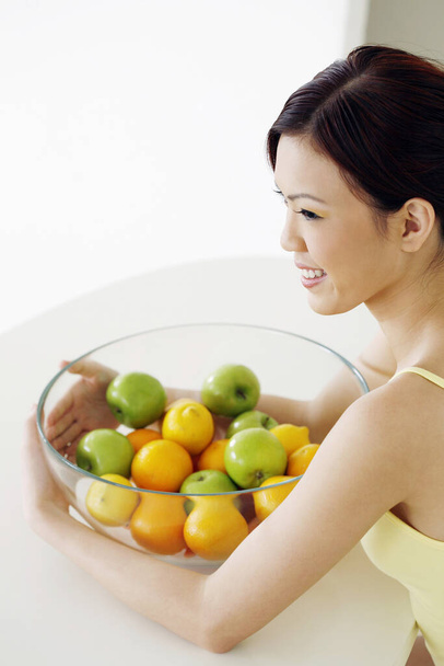 Woman with a bowl of fruits - Foto, afbeelding