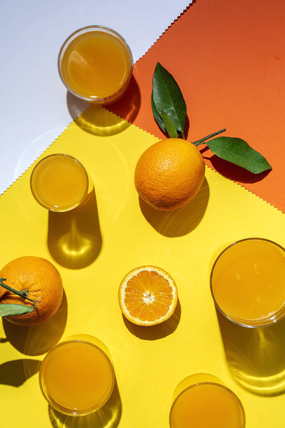 Homemade orange juice from above on colored backgrounds with sunlight.Flat lay.Top view.Healthy drink - Fotografie, Obrázek