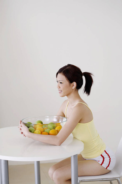 Woman with a bowl of fruits - Foto, Bild