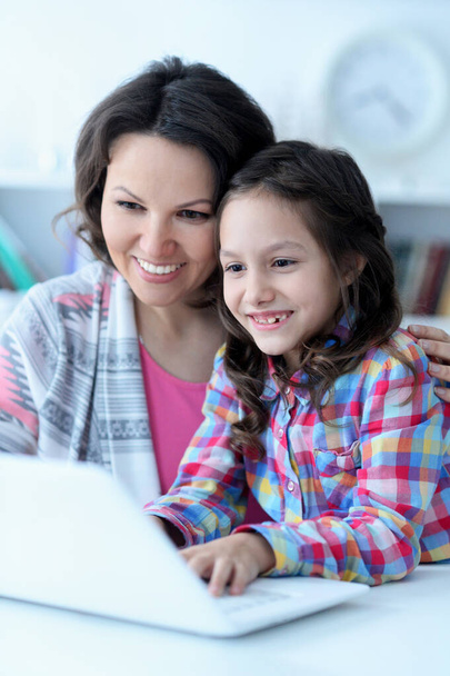 happy mother and daughter using laptop together  - 写真・画像