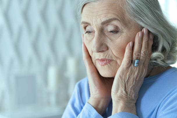 Zamknij portret smutnej starszej kobiety z bólem głowy  - Zdjęcie, obraz