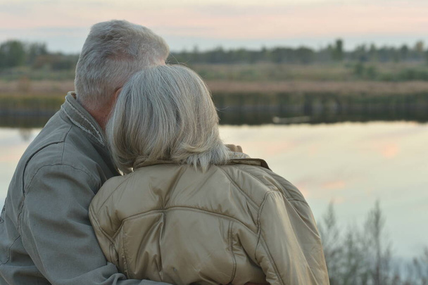 Felice coppia anziana vicino al lago durante il tramonto in estate
 - Foto, immagini