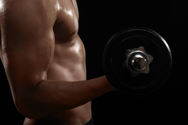 Muscular man lifting dumbbell - Фото, зображення