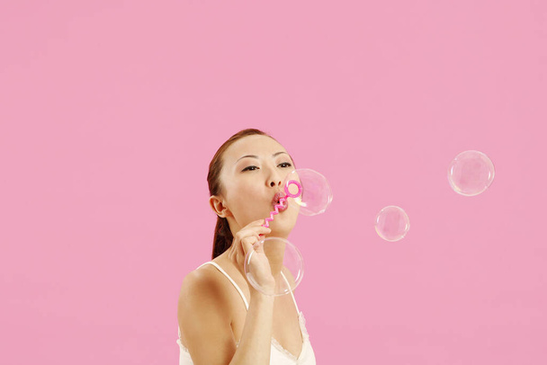 Woman playing with soap bubbles - 写真・画像