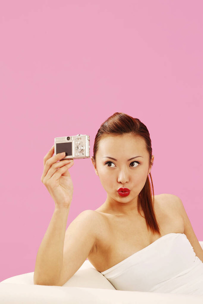 Woman taking self picture with digital camera - Zdjęcie, obraz