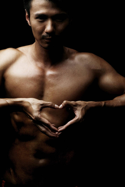Topless man making heart shape with fingers - Foto, afbeelding