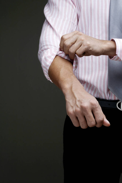 Businessman rolling up his sleeve - Foto, Imagen