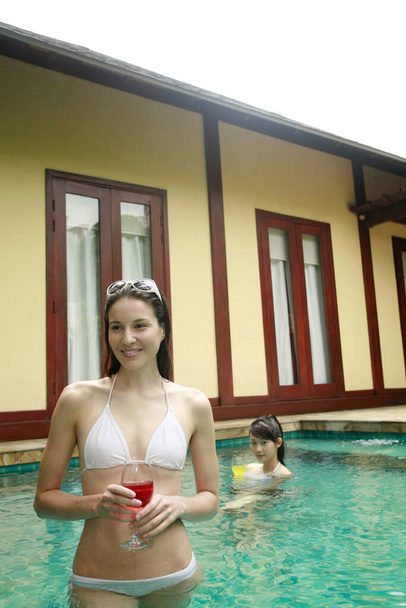 Women enjoying their drink in the pool - 写真・画像
