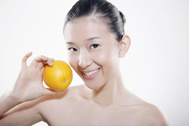 Vrouw met sinaasappel - Foto, afbeelding