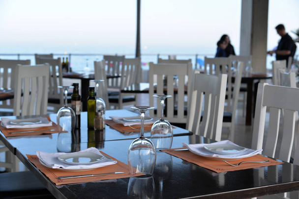 Vaciar copas de vino en una mesa puesta en un café de postre en la playa de mar
. - Foto, Imagen