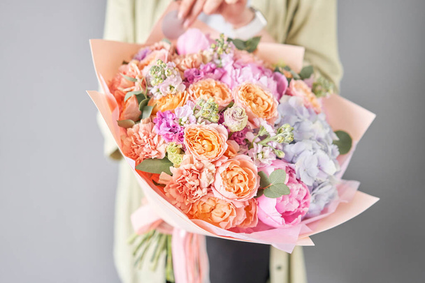 Rózsaszín bazsarózsa és hortenzia. Gyönyörű csokor vegyes virág női kézben. Virágüzlet koncepció. Jóképű friss csokor. Virágszállítás. - Fotó, kép