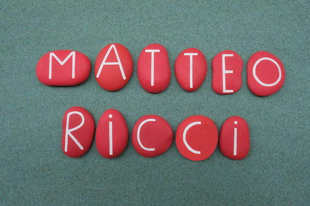Father Matteo Ricci, jesuit, celebrated with red colored stone letters over green sand - Photo, Image