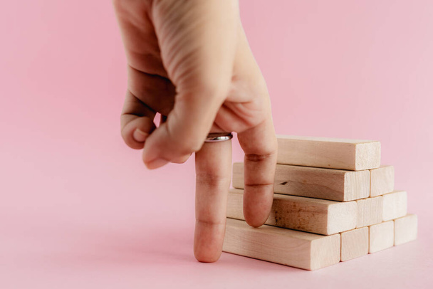 Le dita che si muovono salire la scala giocattolo in legno su sfondo rosa per il concetto di successo step to goal
 - Foto, immagini