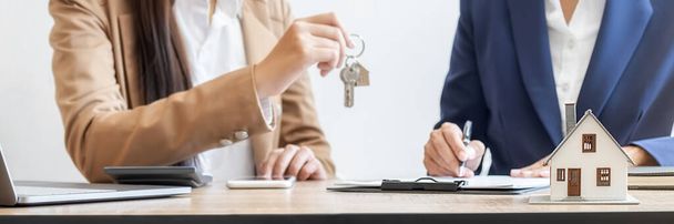 Real estate agent holding a key and asking costumer for contract to buy, get insurance or loan real estate or property. - Foto, immagini
