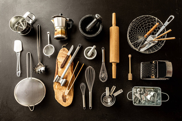 Kitchen utensils (cooking tools) on black chalkboard background. Kitchenware collection captured from above (top view, flat lay). - Photo, Image