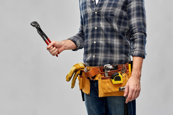 worker or builder with wrench and tools on belt - Фото, изображение