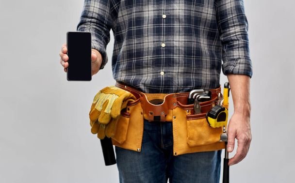 worker or builder with phone and working tools - 写真・画像