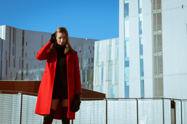 Beautiful girl posing with red coat - Foto, afbeelding