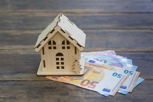 Ein Holzhäuschen steht auf den Euroscheinen 50, 20, 10. Das Konzept des Reichtums, Kauf, Verkauf, Vermietung von Immobilien, Hypothek - Foto, Bild
