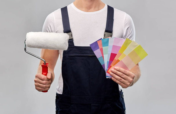 close up of painter with roller and color charts - Φωτογραφία, εικόνα