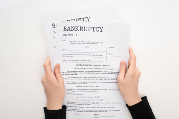 partial view of woman holding bankruptcy papers on white background - Foto, Imagen