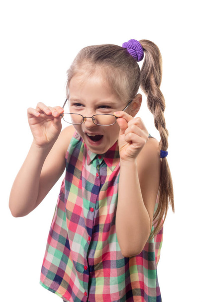 Egy csinos kislány szemüvegben, fehér háttéren pózol. Rossz látású gyermek - Fotó, kép