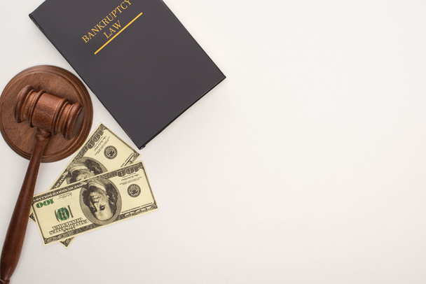 Draufsicht auf Insolvenzrechtsbuch, Hammer und Geld auf weißem Hintergrund - Foto, Bild