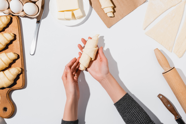 kivágott kilátás nő gyártás croissant fehér háttér - Fotó, kép