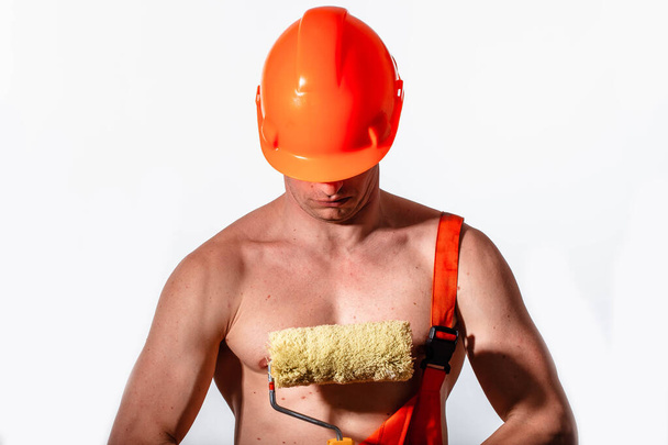 Sexy trabajador de la construcción sobre un fondo blanco. Constructor con un casco en la cabeza. Constructor sexy
. - Foto, Imagen