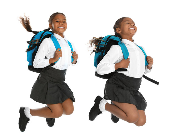 African American girl in school uniform jumping on white background - Foto, afbeelding