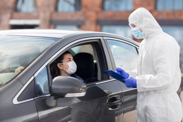 healthcare worker with clipboard and woman in car - Foto, Bild