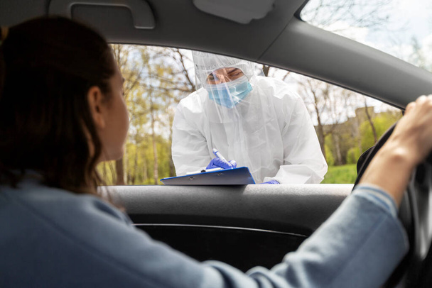 healthcare worker with clipboard and woman in car - Фото, зображення