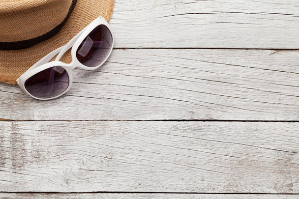 Travel concept backdrop with sun hat and sunglasses on wooden table. Top view flat lay with copy space - Photo, Image