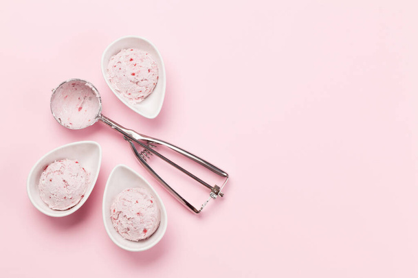 Raspberry ice cream scoops in bowls and icecream spoon on pink background. Top view with copy space - Photo, image