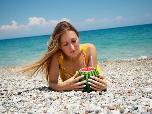 Woman on the beach with watermelon cocktail - Foto, afbeelding