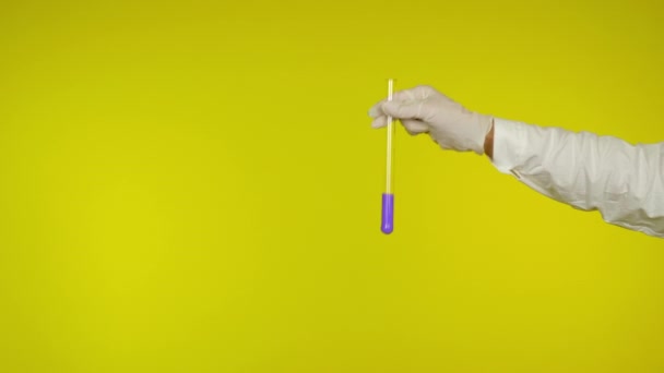 Hand-in-Hand-Handschuhschutz zeigt ein Glasrohr mit der lila Substanz - Filmmaterial, Video