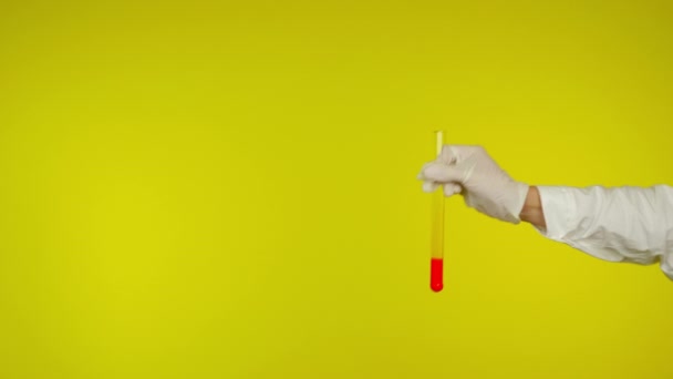 Hand in hand latex handschoen bescherming toont een glazen buis met de rode stof - Video