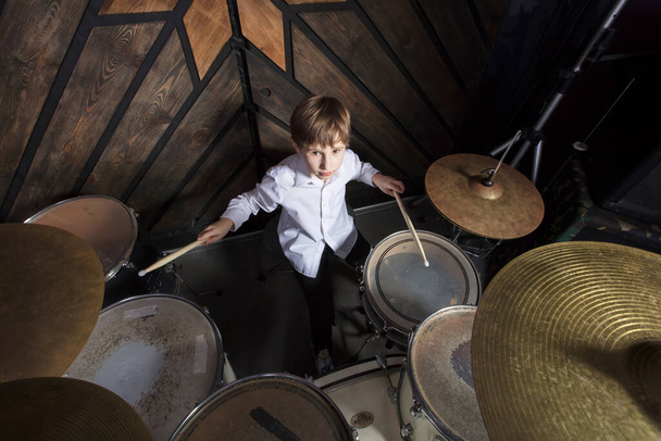 The boy learns to play the drums. The child behind the drum kit. - Fotoğraf, Görsel