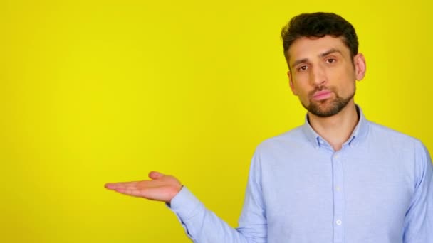 Hombre con camisa azul demuestra un producto imaginario en la palma de su mano
 - Metraje, vídeo
