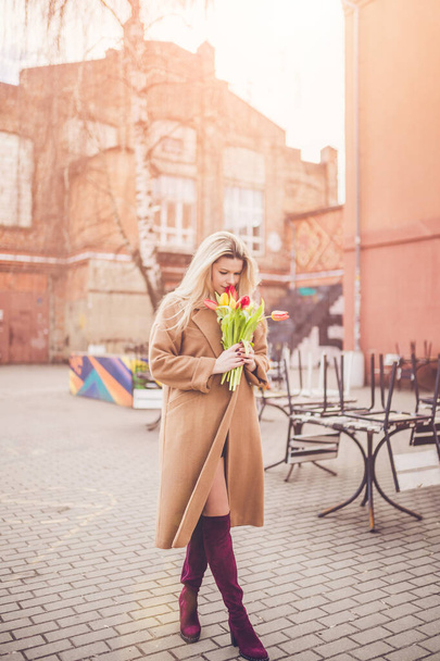 Portrait of a young beautiful sexy lady with a bouquet of flowers on International Women's Day - Foto, Bild