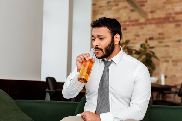 bezrobotny Afroamerykanin pijący piwo w domu - Zdjęcie, obraz