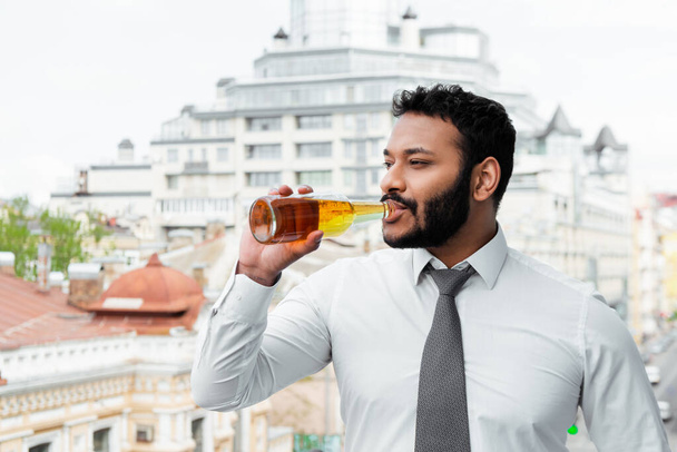barbudo afroamericano hombre en máscara médica beber cerveza fuera
 - Foto, Imagen