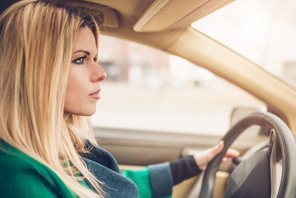 Beautiful attractive sexy Scandinavian blonde with big blue eyes behind the wheel of a car - focused on driving - inexperienced driver - Foto, Imagem
